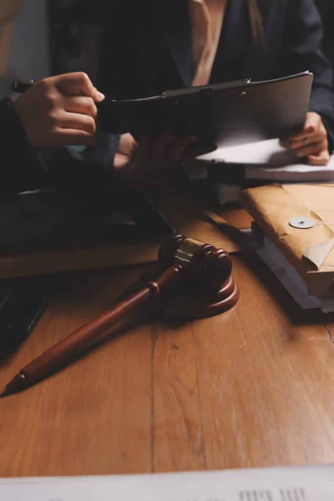 attractive young lawyer office business woman lawyers discussing contract papers with brass scale wooden desk office law legal services advice justice real estate concept