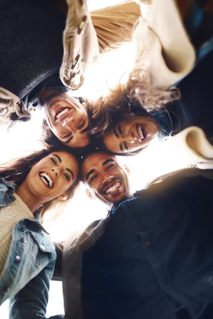 low angle portrait friends with laughing hug connection bonding together vacation diversity men women with huddle embrace solidarity support group people by